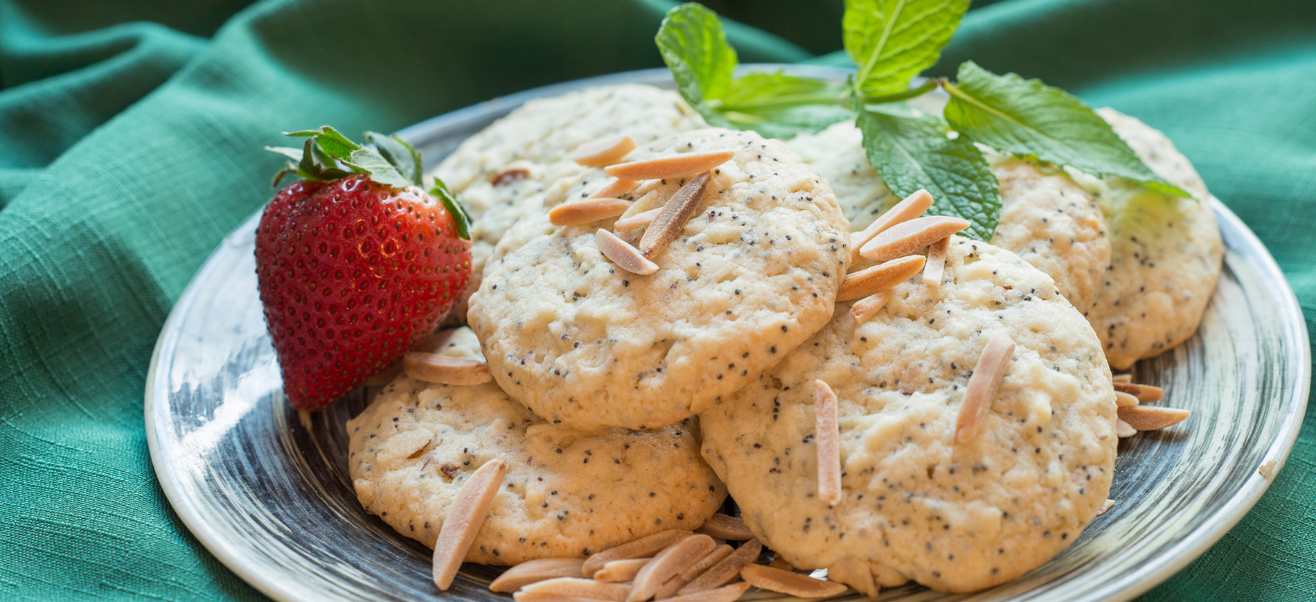 Almond Poppyseed Cookies on plate with strawberry and mint