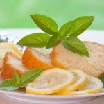 Slices of lemon basil cake garnished with fresh lemon slices and basil