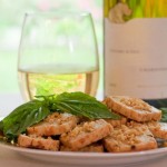 basil pignoli bites with glass of wine and wine bottle