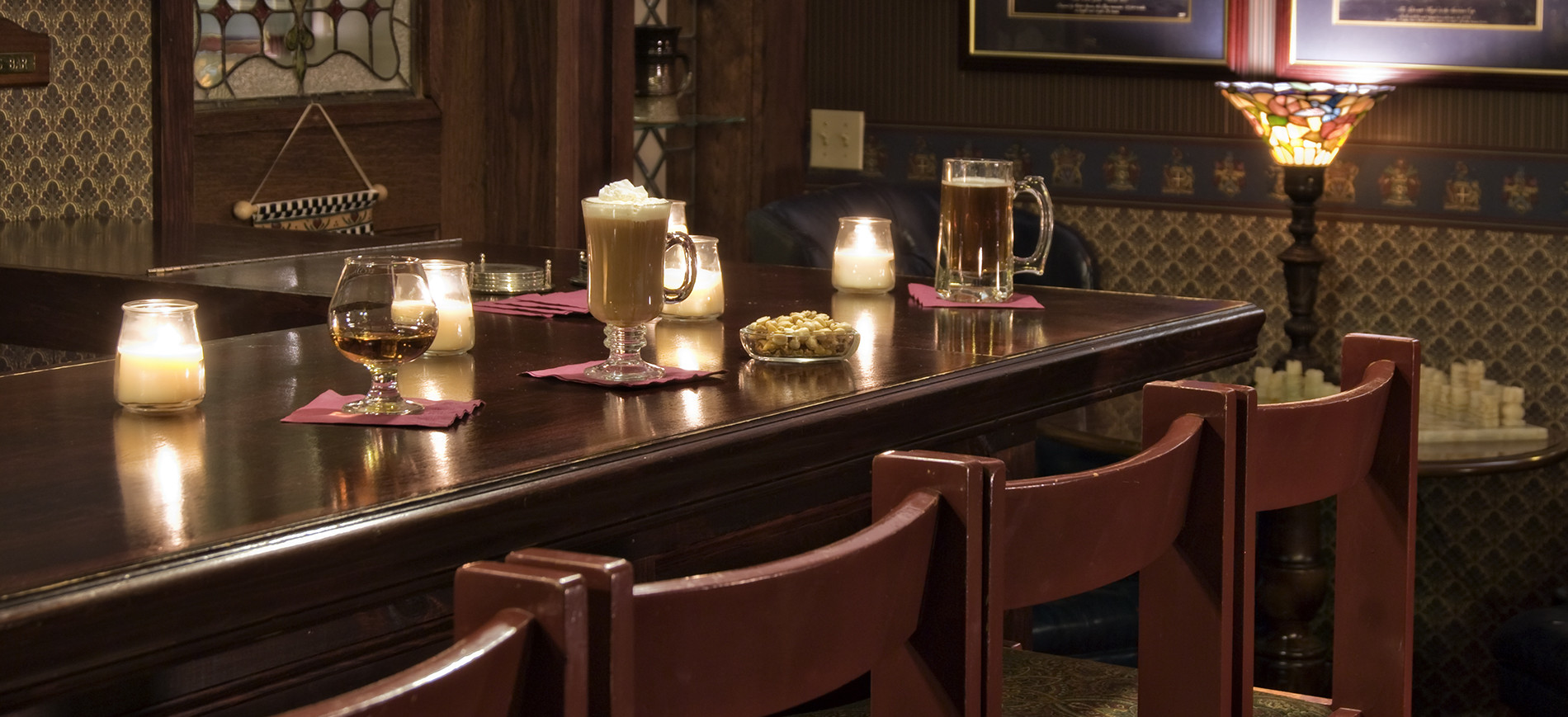 Bar stools & bar with drinks & candles on top