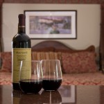 glasses of red wine with bottle of wine in bedroom