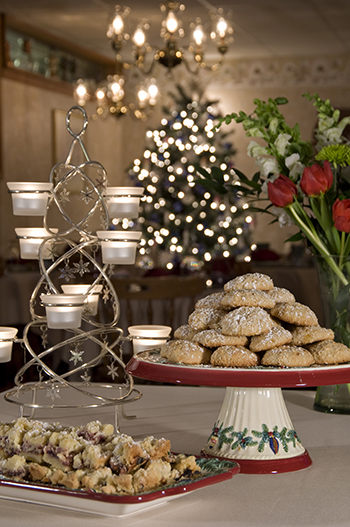 Platter & stand of cookies with votive candle tree, flowers, and Christmas tree in background