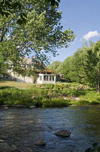 Ellis River in foreground, Inn at Ellis River on far bank of river with trees