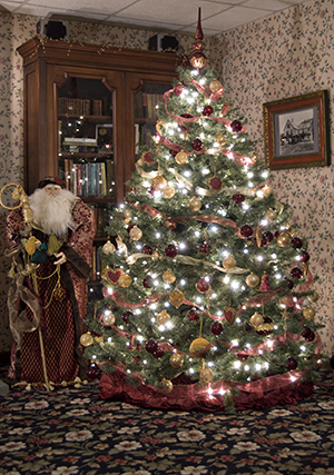 St.. Nicholas figure on left, Chrismas tree in front of glass front bookcase on right